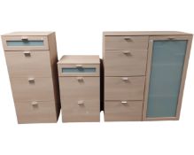 A light oak three drawer storage chest together with matching four drawer chest and glazed door