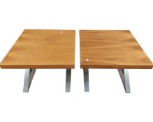A pair of contemporary lamp tables with metal stretchers