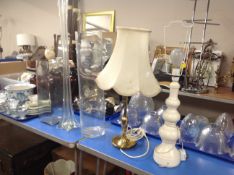 Three large glass vases together with two table lamps with shades.