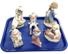 A tray of six Lladro and Nao figures including clowns and a figure of a girl.