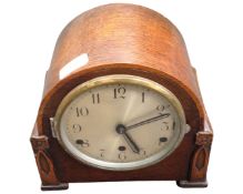 An eight-day chiming mantel clock, in oak case, with silvered dial, with pendulum, with key,