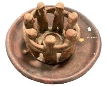 A pottery bowl on metal stand together with a pottery candle holder.