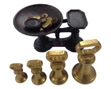 A graduated set of four brass weight together with a set of vintage scales with further weights.