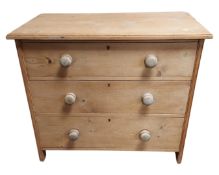 An antique pine three drawer chest.