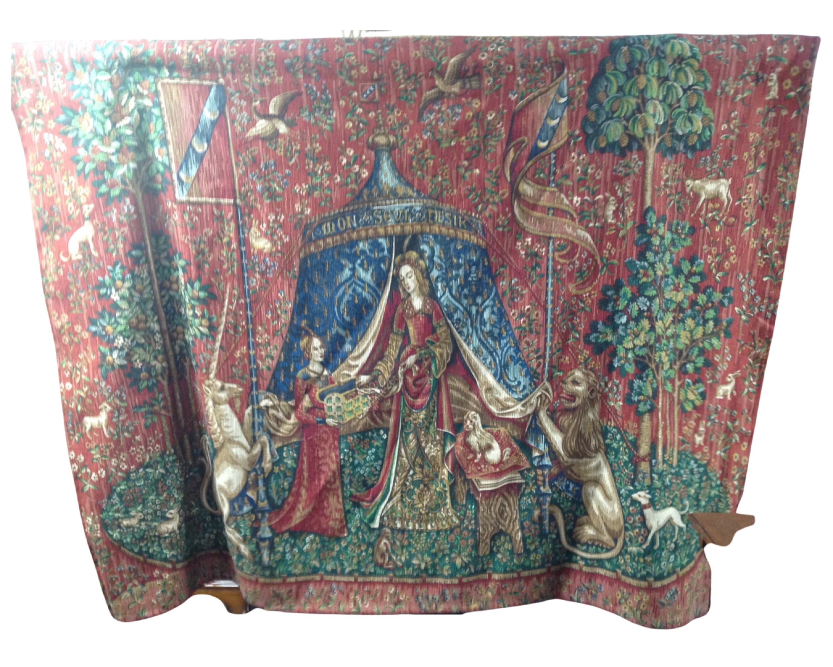 A traditional style embroidered tapestry hanging on metal rail