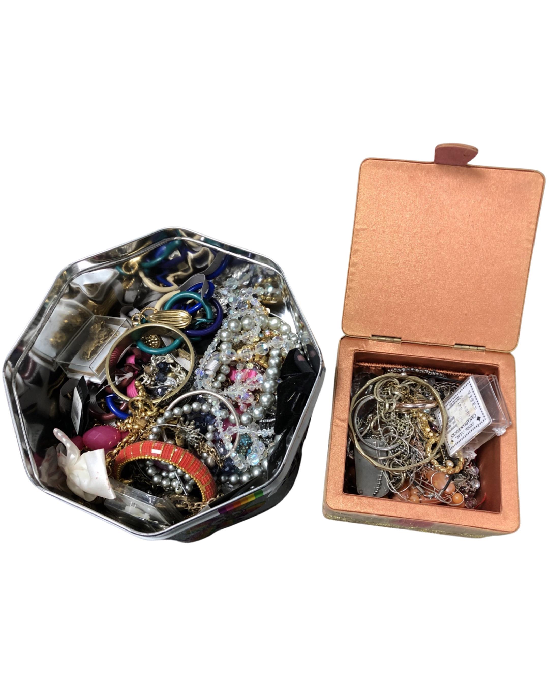 A tin and a small box of costume jewellery.