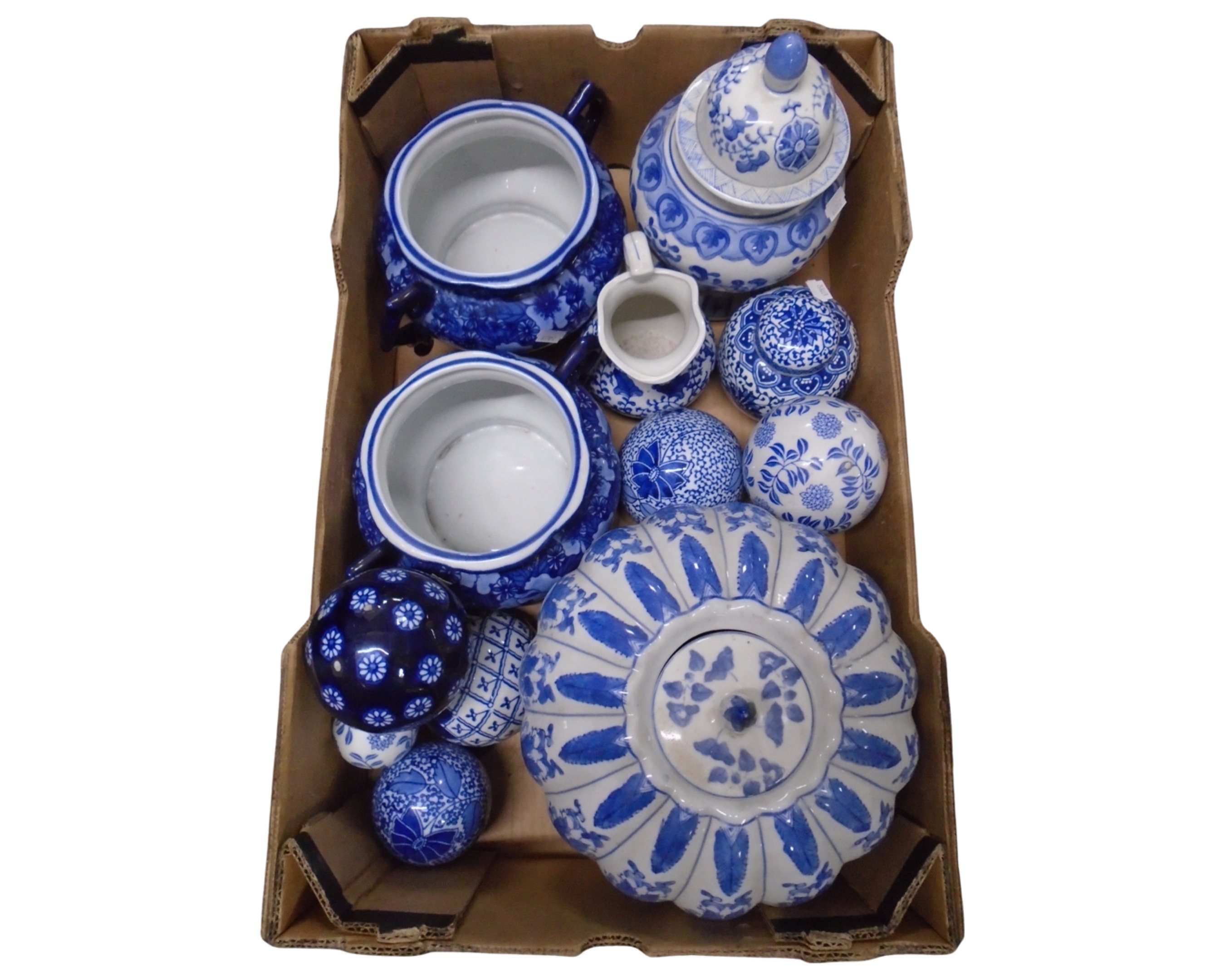 A box containing a blue and white jardiniere, ceramic vase with cover, ceramic balls.