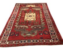 An Afghan/Caucasian carpet of geometric design on red ground, 192cm by 270cm.
