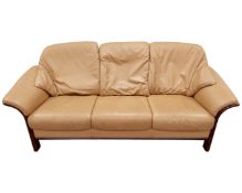 A Scandinavian beech framed three seater settee in tan leather upholstery.