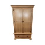 A contemporary light oak double door wardrobe fitted with a drawer.
