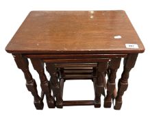 A nest of three stained oak tables.