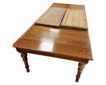 An oak extending dining table together with six pine leaves.