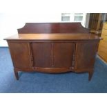 An early 20th century mahogany four door sideboard on raised legs.