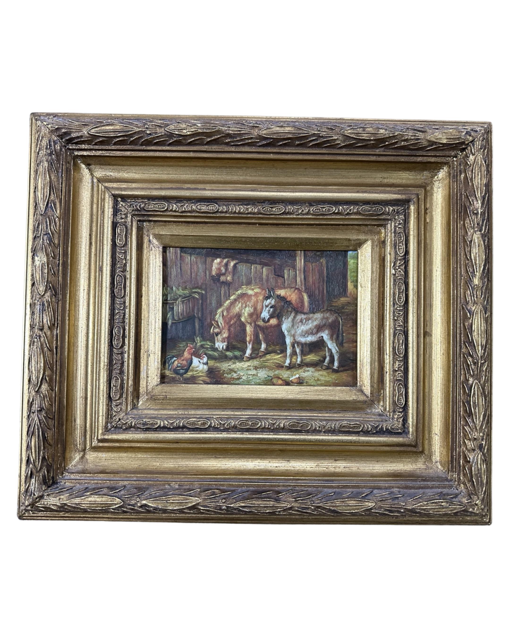 A gilt framed oil on panel depicting two donkeys and a chicken in a barn, 16cm by 11cm.