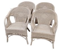 A set of four painted wicker armchairs.