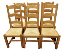 A set of six oak ladder back dining chairs with rush seats.