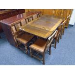 An Edwardian oak drop leaf table together with six chairs.