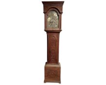 A 19th century Continental carved oak 30 hour long case clock with brass dial and weights.