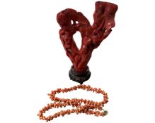 A Chinese coral carving on hardwood stand (height 14cm), together with a coral necklace.