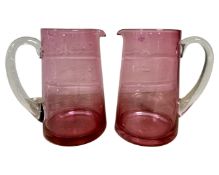 A pair of cranberry glass jugs.