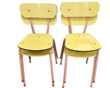 A set of four plywood and metal stacking chairs.