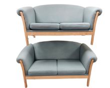 A pair of Scandinavian beech framed two seater settees upholstered in turquoise fabric.