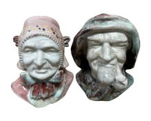A pair of early 20th century glazed pottery busts depicting a man smoking a pipe and a lady with