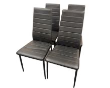 A set of four contemporary black vinyl chairs.