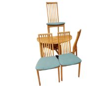 A pine effect drop leaf dining table together with a set of four chairs.