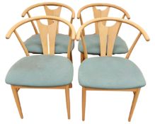 A set of four beech framed elbow chairs.