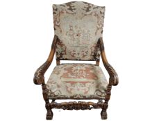 A late 19th century Continental heavily carved oak armchair with tapestry upholstered seat.