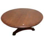 A circular mahogany coffee table on triform base,