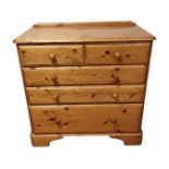 A contemporary pine chest of five drawers.