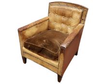 An Edwardian tub chair in brown studded leather upholstery.
