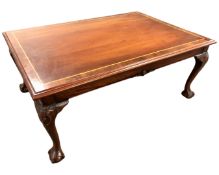 A reproduction inlaid mahogany rectangular coffee table on claw and ball feet.