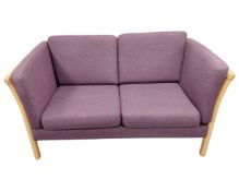 A Scandinavian beech framed two seater settee in purple upholstery.