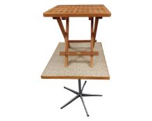 A teak folding lattice table together with a further cafe table on metal base.