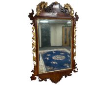 A George III carved walnut and parcel gilt wall mirror, 74cm by 118cm.