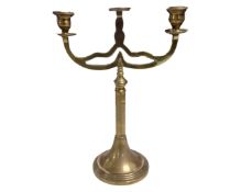 An antique brass three way candelabrum.