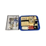 A tray containing costume jewellery, playing cards, cased cutlery,