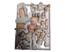 A tray containing a collection of antique china doll's heads and figurines.