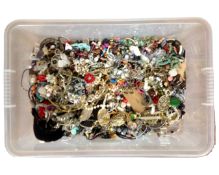 A plastic box containing a large quantity of assorted costume jewellery.