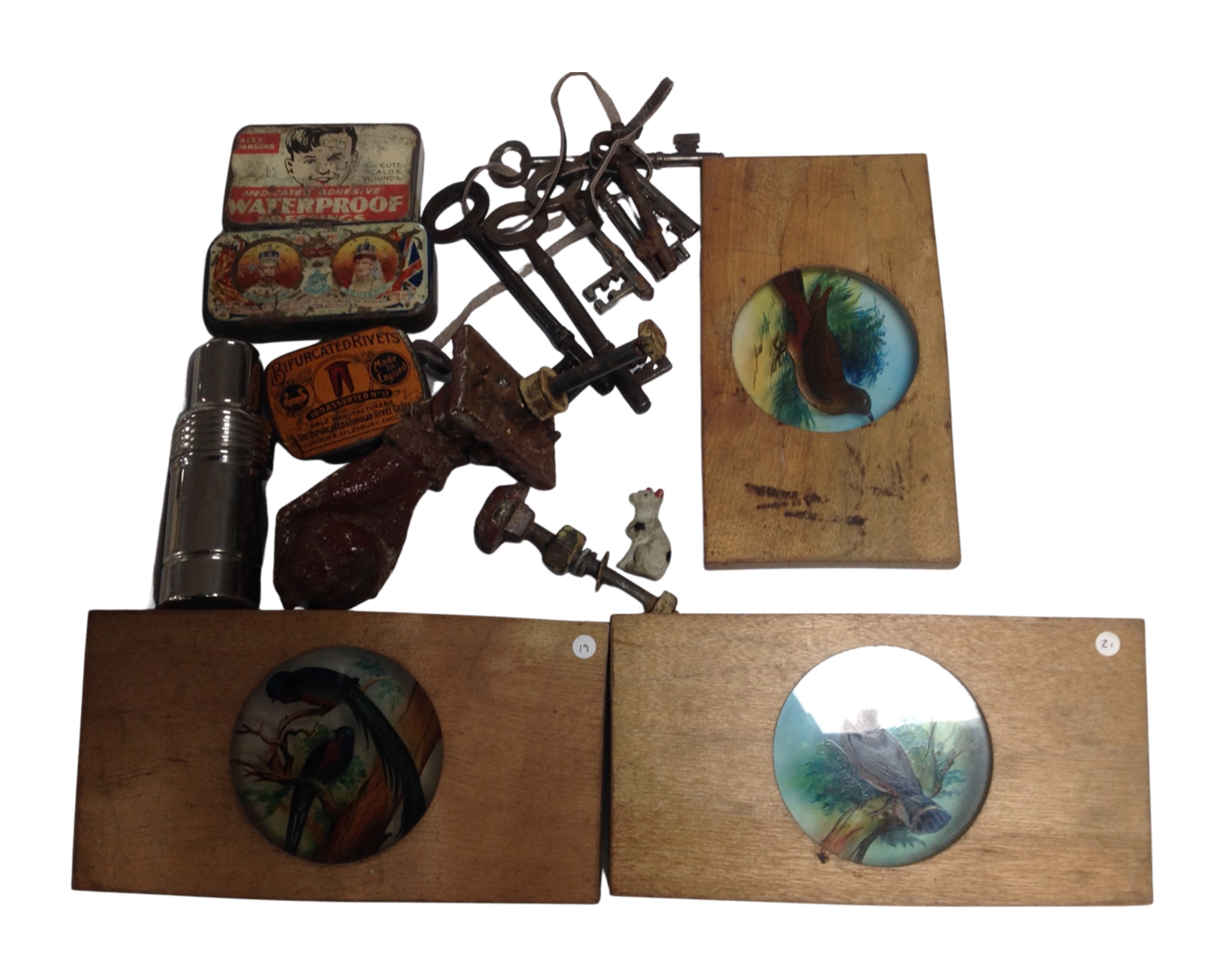 A tray containing antique keys, vintage tins, a 19th century door knocker in the form of a hand,