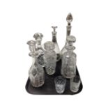 A tray containing six cut glass and lead crystal decanters together with a further pair of whiskey