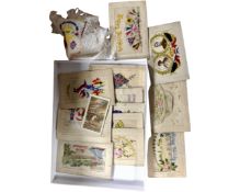 A collection of early 20th century embroidered postcards and silks together with a further