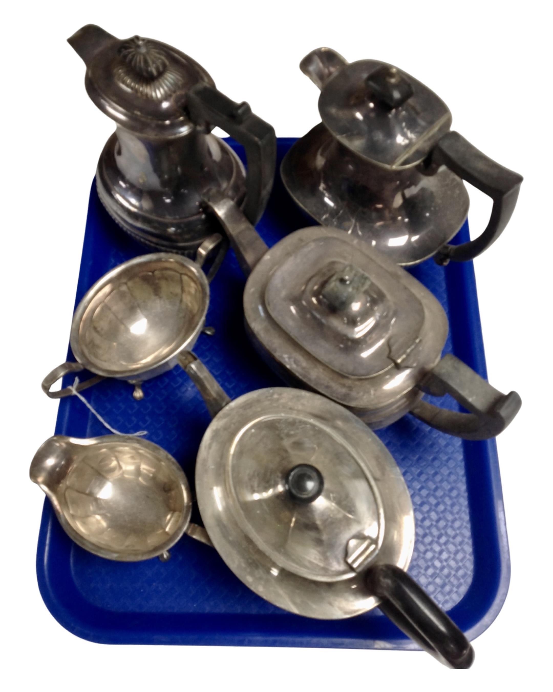 A three piece plated tea service together with three further plated tea and coffee pots.