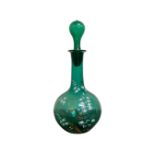An early 19th century green glass decanter with painted gilt and white decoration, height 27.5 cm.