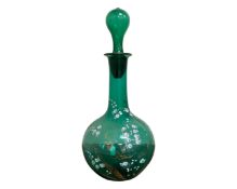 An early 19th century green glass decanter with painted gilt and white decoration, height 27.5 cm.