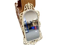 A decorative metal cream and gilt framed mirror