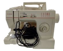 A Singer electric sewing machine with foot pedal and cover.